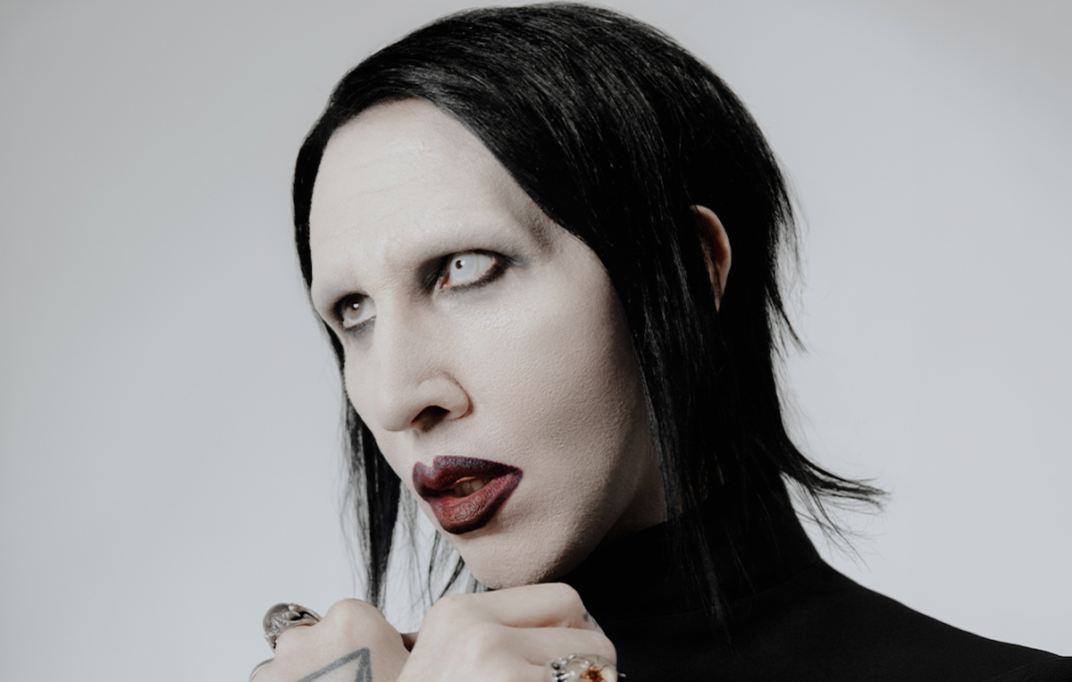 Promotional portrait of industrial rock musician Marilyn Manson featuring signature dark makeup and white contact lens.